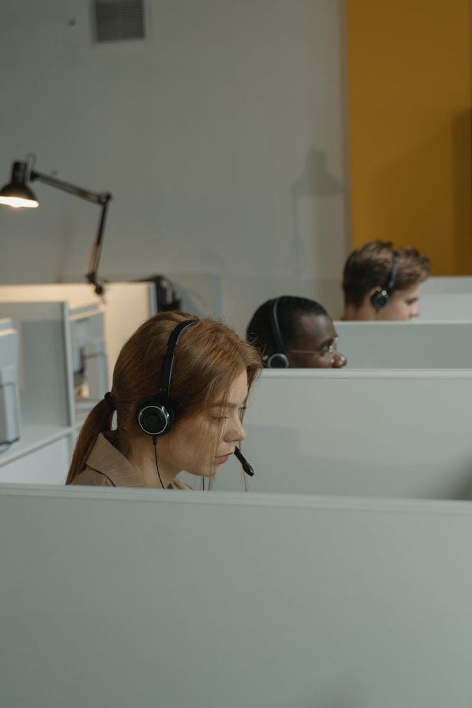 Différents agents de centre d'appels concentrés sur leurs tâches dans un espace de travail moderne avec des casques.