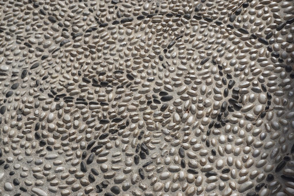 Revêtement en moquette de pierre : texture de granulats minéraux incrustés en résine polyuréthane, sol extérieur durable exposé en plein soleil