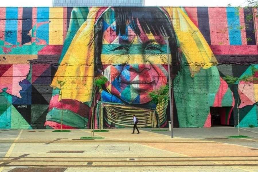 Une immense fresque murale colorée représentant le visage expressif d'une personne dans l'esprit artistique de Holbox.